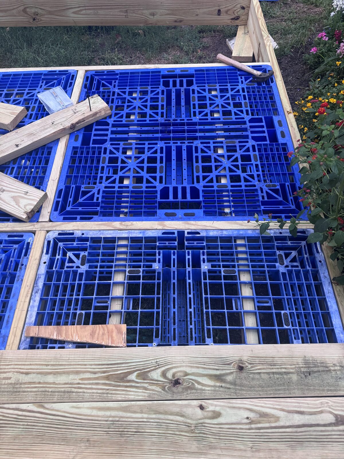 Looking down into a pallet: two 2x4s run through the fork pockets.