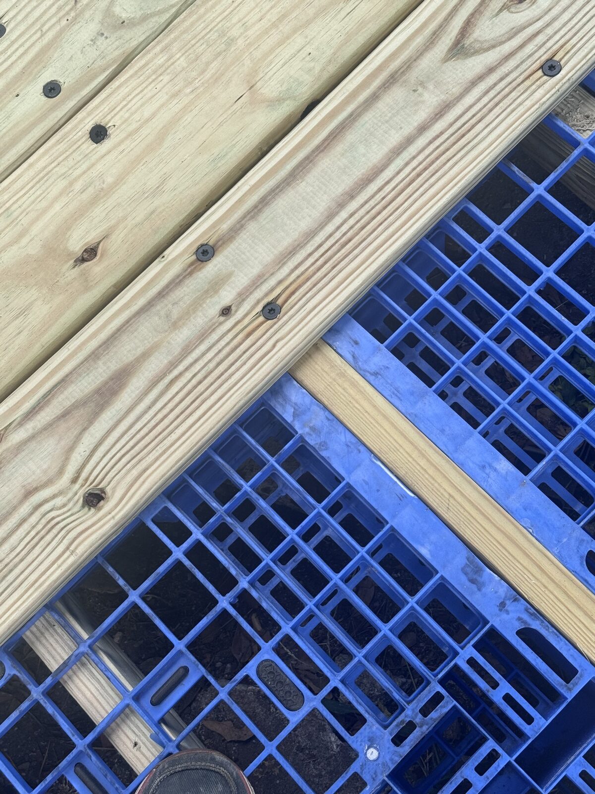 Deck screws through a board and the pallet top into the 2x4.